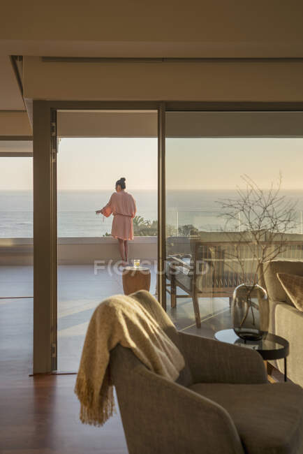 Mujer en patio de lujo disfrutando de vistas panorámicas al mar - foto de stock