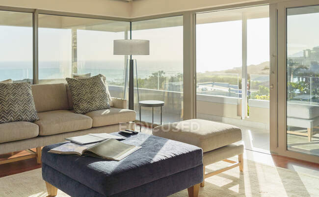 Casa ensolarada vitrine interior sala de estar com vista mar — Fotografia de Stock