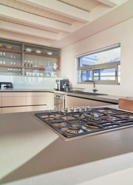 Plaque de cuisson au gaz sur le comptoir ensoleillé de la maison vitrine cuisine intérieure — Photo de stock