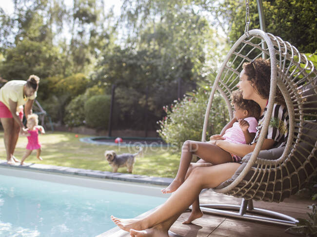 Família brincando e relaxando na piscina ensolarada de verão — Fotografia de Stock