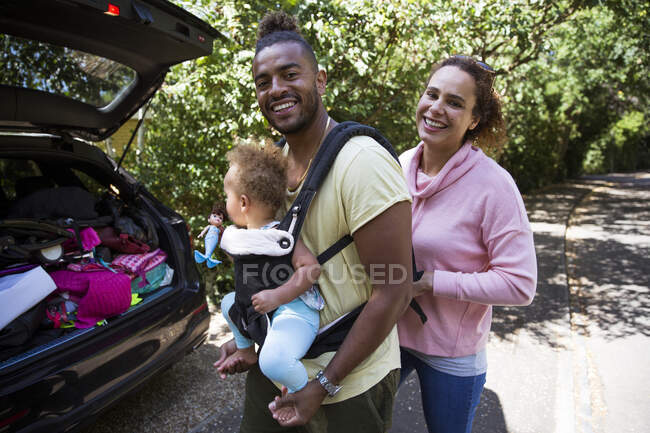 Retrato casal feliz com bebê filha fora do carro — Fotografia de Stock