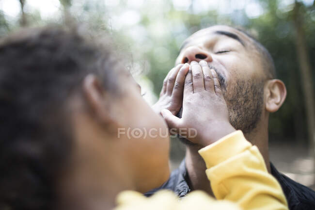 Filha brincalhão cobrindo boca de pai — Fotografia de Stock