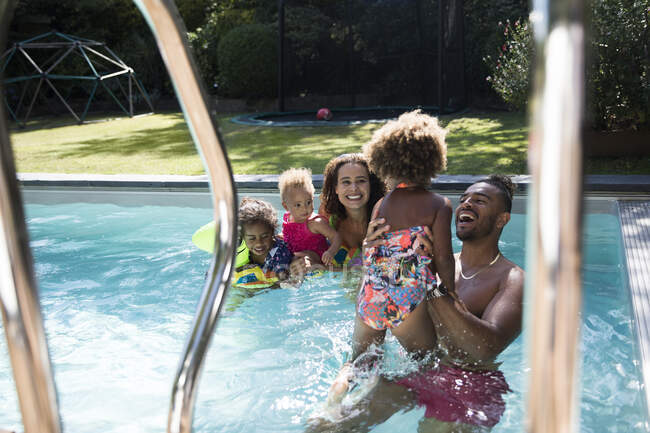 Famiglia felice che gioca in piscina — Foto stock