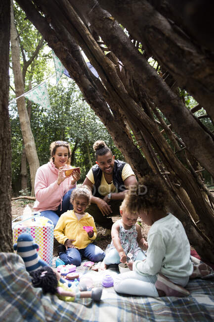 Familia disfrutando de una fiesta de té en fort al aire libre - foto de stock
