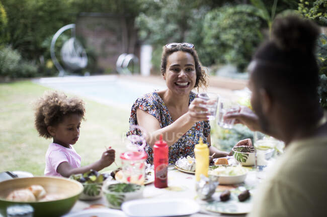 Счастливая семья наслаждается летним барбекю во внутреннем дворике — стоковое фото
