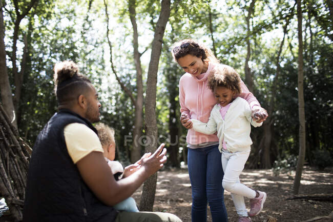 Happy family playing among trees in woods — Stock Photo