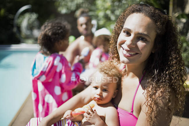 Portrait happy mother and daughter at sunny summer poolside — Stock Photo
