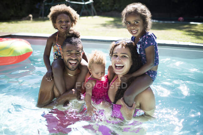 Portrait happy excited family playing in sunny summer swimming pool — Stock Photo