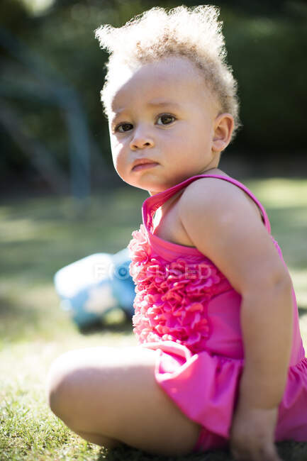 Retrato linda niña en la hierba del parque soleado - foto de stock