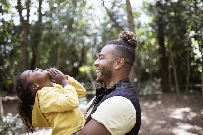 Père heureux tenant fille dans les bois — Photo de stock