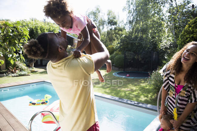 Glückliche Familie spielt am sonnigen Sommerpool — Stockfoto
