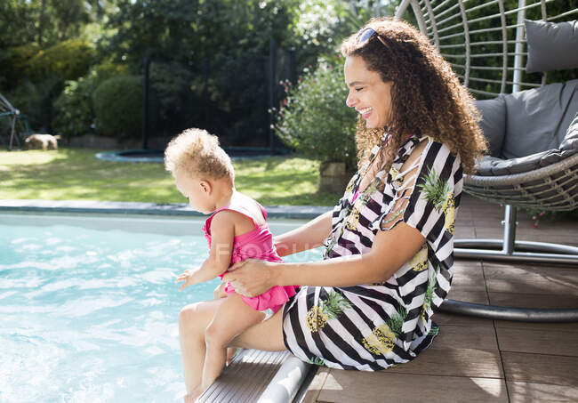 Mãe feliz e filha criança na ensolarada piscina de verão — Fotografia de Stock