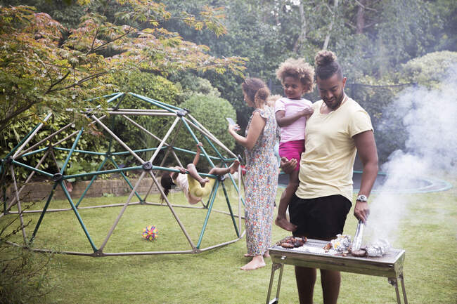 Familie grillt und spielt im Sommergarten — Stockfoto