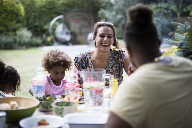 Happy family enjoying lunch on summer patio — Stock Photo
