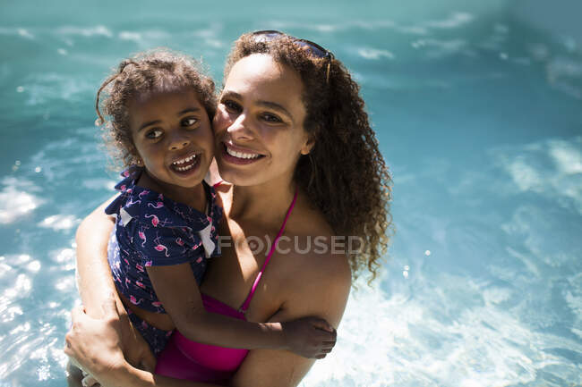 Ritratto felice madre e figlia nella soleggiata piscina estiva — Foto stock