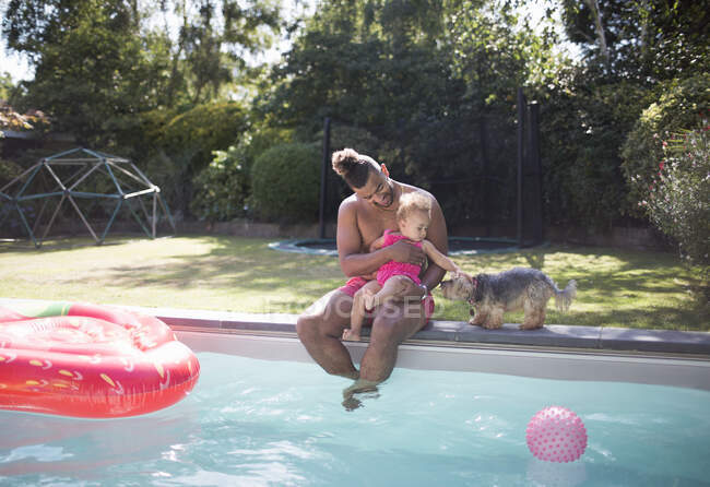 Father and toddler daughter with dog at summer swimming pool — Stock Photo
