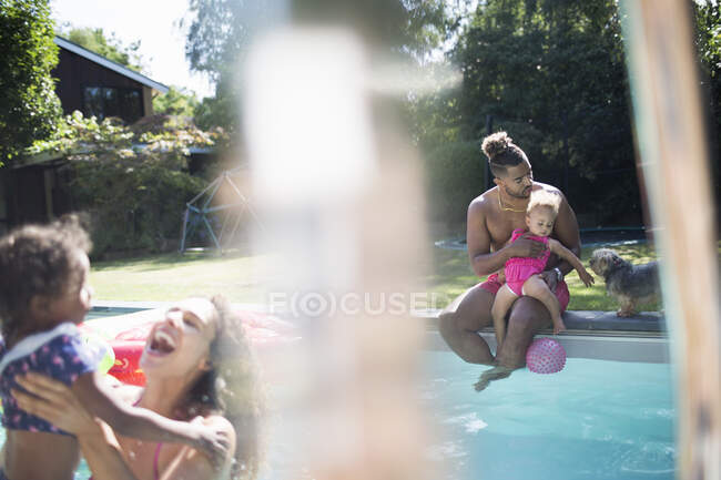 Family relaxing and playing at sunny summer backyard swimming pool — Stock Photo