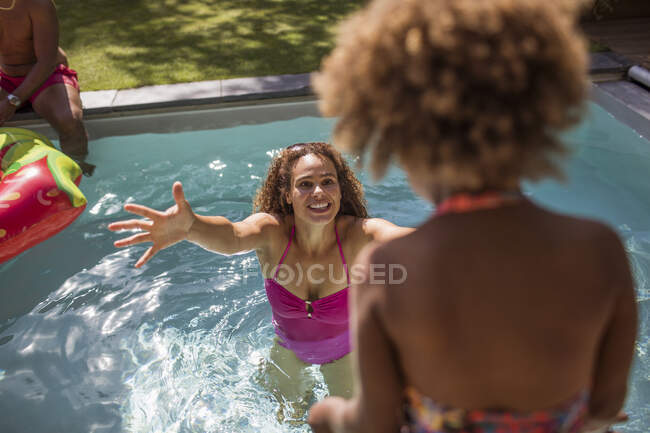Mãe feliz à espera de filha para saltar em braços na piscina — Fotografia de Stock