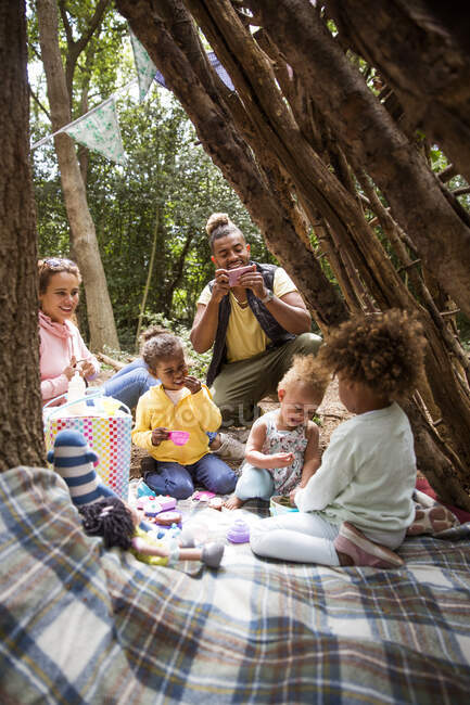 Famille jouer thé partie dans l'arbre fort — Photo de stock