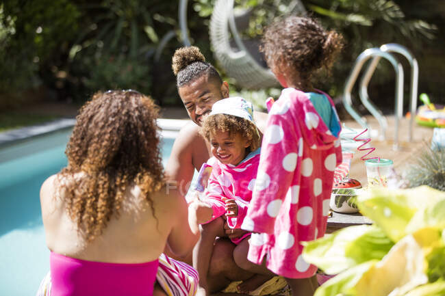 Glückliche Familie entspannt sich am sonnigen Sommerpool — Stockfoto
