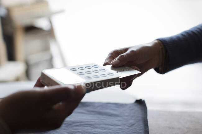 Close up customer with credit card using swiper in shop — Stock Photo