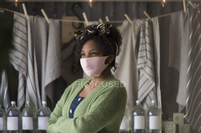 Portrait confident female shop owner in pink face mask — Stock Photo