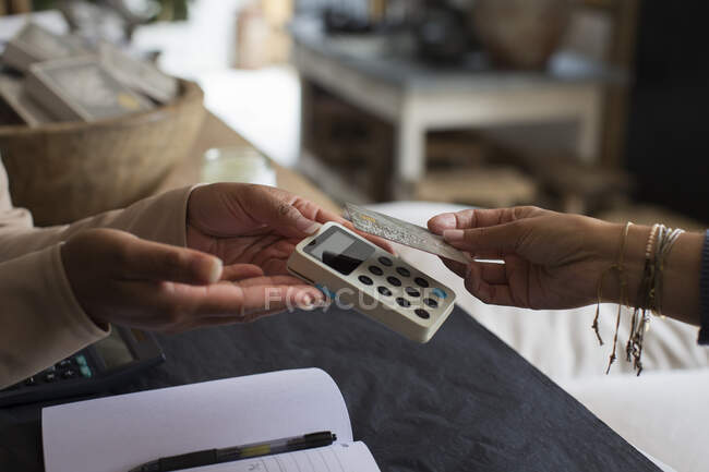 Großer Kunde bezahlt Ladenbesitzer mit Chipkarte — Stockfoto