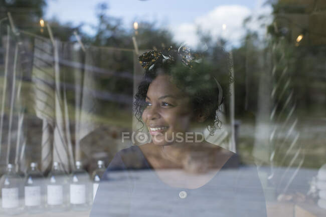 Sorrindo dono da loja feminina na janela — Fotografia de Stock