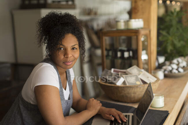 Портрет впевненого власника жіночого магазину, використовуючи ноутбук у розплідниках рослин — стокове фото