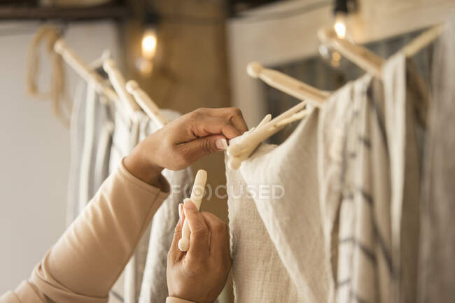 Close up donna negozio proprietario appeso tessuto — Foto stock