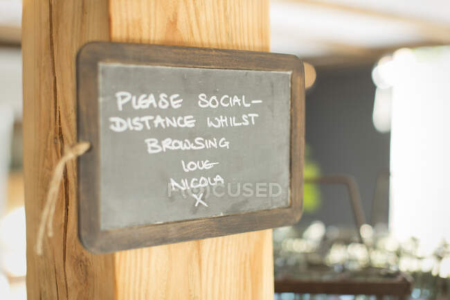Blackboard social distancing sign in small shop — Stock Photo