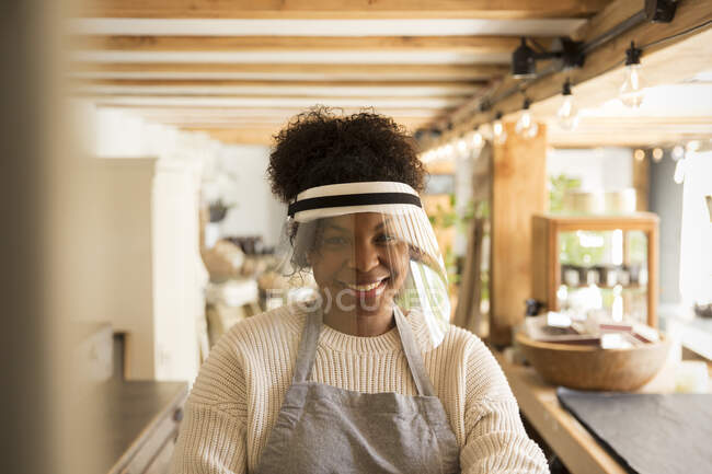 Portrait happy female shop owner wearing face shield — Stock Photo