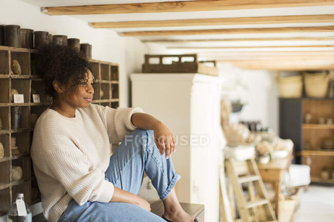 Thoughtful female shop owner looking away — Stock Photo