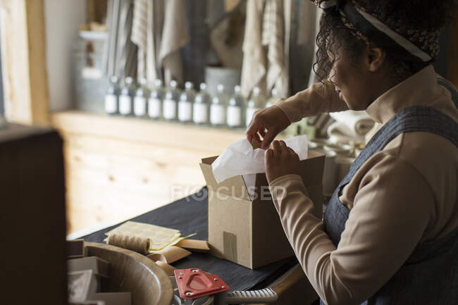Proprietaria negozio femminile preparare il pacchetto al banco del negozio — Foto stock