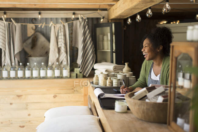 Happy female shop owner laughing at shop counter — Stock Photo