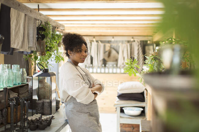 Dono de loja feminina confiante em avental em viveiro de plantas — Fotografia de Stock