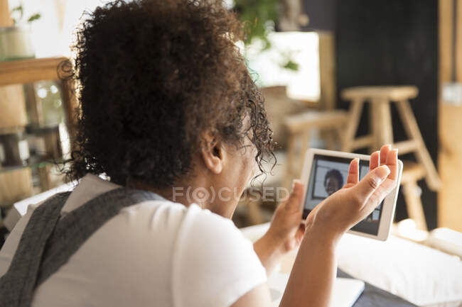 Donna negozio proprietario video chat con un amico su tablet digitale — Foto stock