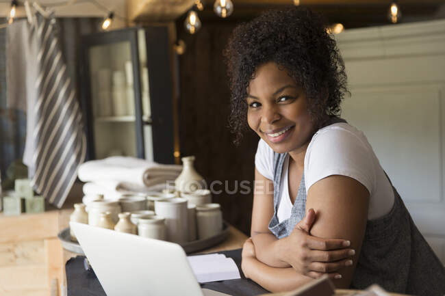 Portrait confident female shop owner working at laptop on counter — Stock Photo