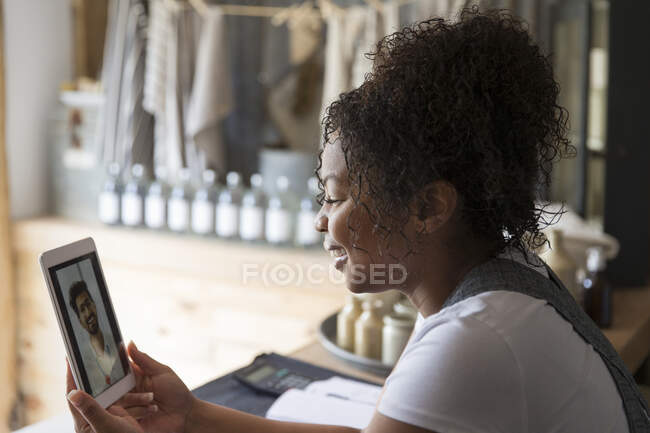 Verkäuferin chattet mit Freundin auf digitalem Tablet — Stockfoto