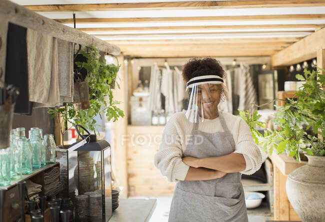 Retrato confiante proprietário da loja feminina no escudo facial no berçário da planta — Fotografia de Stock