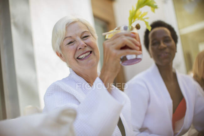 Happy senior women friends drinking cocktail on hotel patio — Stock Photo