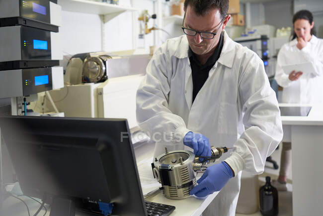 Homme scientifique utilisant un équipement informatique en laboratoire — Photo de stock