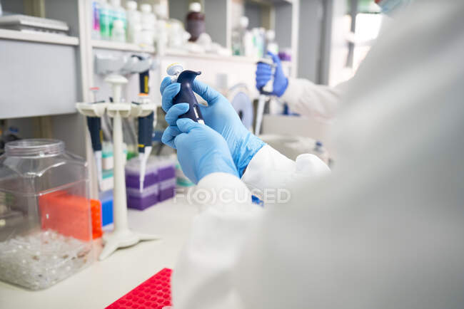 Cientista em luva de borracha preparando pipeta em laboratório — Fotografia de Stock