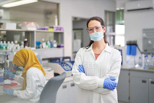 Portrait confident female scientist in face mask and rubber gloves — Stock Photo