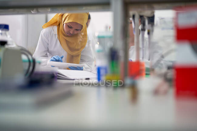 Cientista feminina em hijab com tablet digital em laboratório — Fotografia de Stock