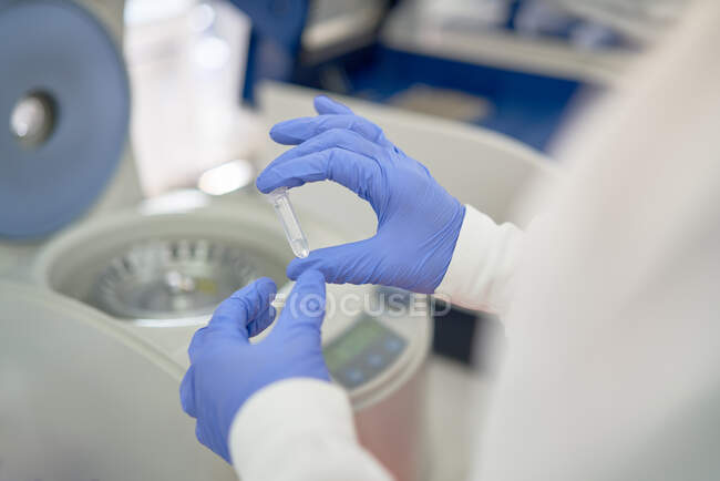 Primo piano scienziato in guanti di gomma mettendo campione in centrifuga — Foto stock