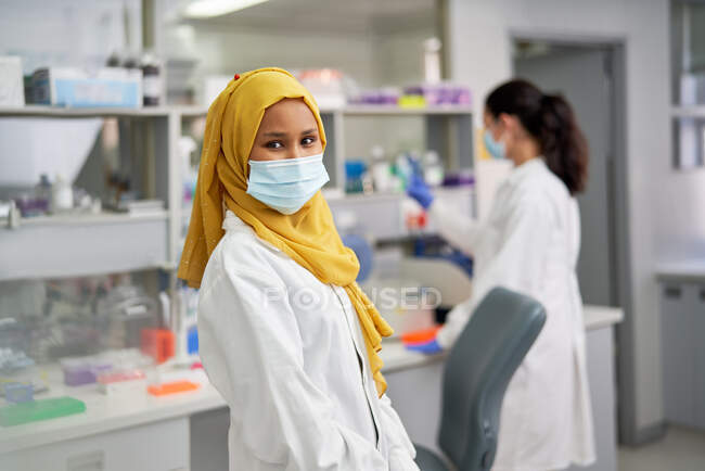 Portrait femme scientifique confiante en hijab et masque facial — Photo de stock
