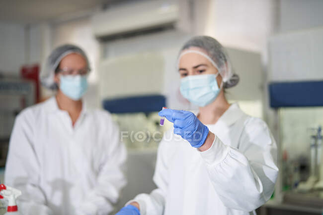 Wissenschaftlerinnen in Schutzkleidung untersuchen Probe — Stockfoto