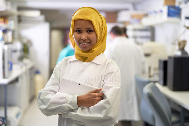 Portrait confident female scientist in hijab working in laboratory — Stock Photo