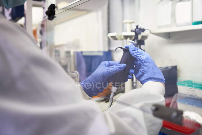 Nahaufnahme Wissenschaftler mit Pipette unter Dunstabzugshaube im Labor — Stockfoto